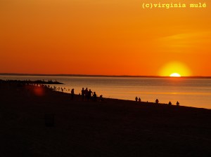 Beachgoers catch the last of the sun's rays on a late summer evening.